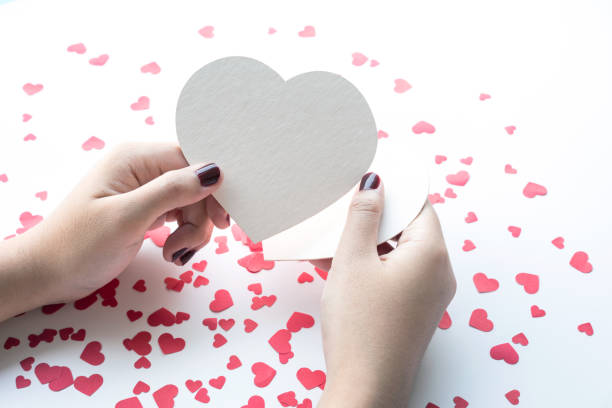 istock Female with white paper heart shape on small red hearts 896968150