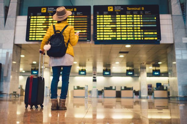Tourist at Barcelona international airport Young woman at the airport in Barcelona checking for the flight schedule airport terminal stock pictures, royalty-free photos & images