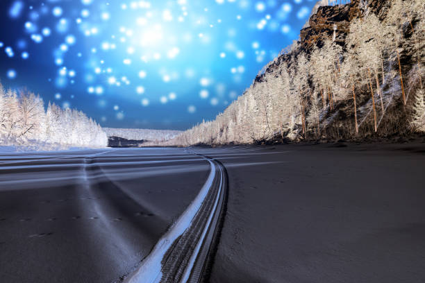 istock Snowmobile track on frozen mountain river 896975894