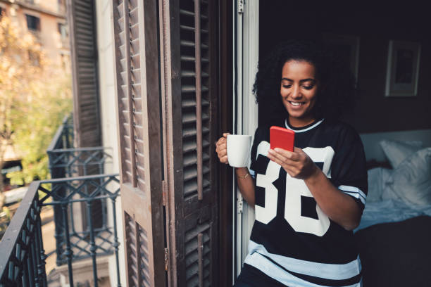 istock Cheerful woman texting at the balcony 896976344
