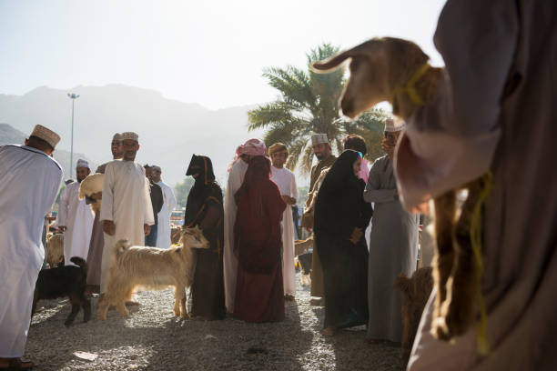 Nizwa, Oman - April 21, 2017: Omani men and women gather at the Friday morning goat market in Nizwa, Oman.