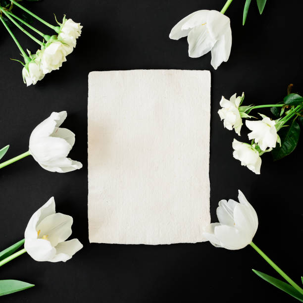 istock White flowers and paper card on black background. Modern composition. Flat lay, top view. 896984474