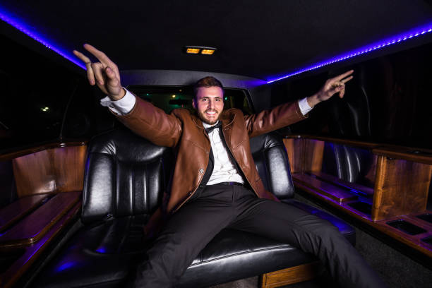 limo rider posing exuberantly - high society men tuxedo party imagens e fotografias de stock