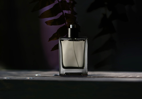 A bottle of men's perfume on a dark background.