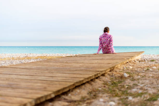 istock A young woman is sitting on a beach 897020602