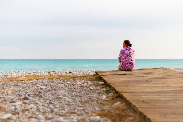 istock A young woman is sitting on a beach 897020812