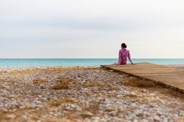istock A young woman is sitting on a beach 897026250
