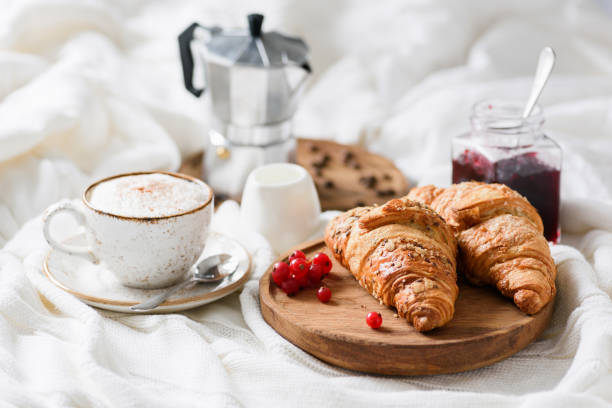 Breakfast in bed with croissants, coffee and jam Breakfast in bed with croissants, jam, coffee cappucino with cream and milk foam. Horizontal view continental breakfast photos stock pictures, royalty-free photos & images