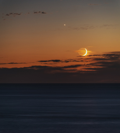 Waxing crescent Moon and Jupiter near the Western horizon on the Bay of Fundy.  Long exposure.