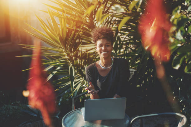 istock Smiling black lady with laptop and smartphone 897033412