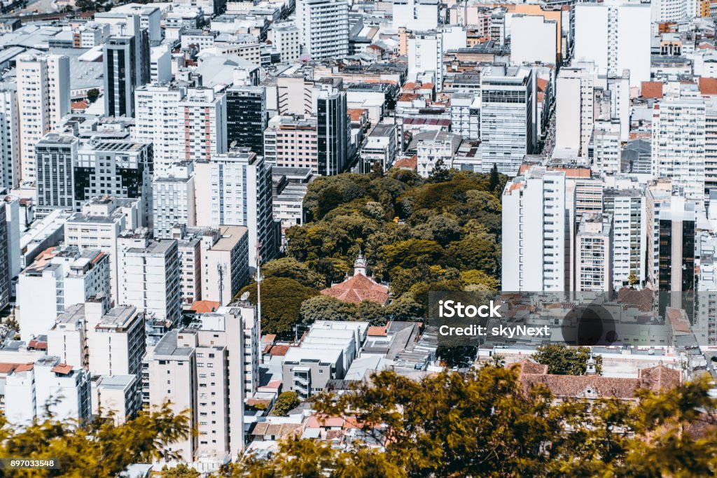 District in Brazilian city from high above View from high point of modern urban cityscape on very bright summer day: multiple multistorey residential and office buildings, park with church in center, streets with people; Juiz de Fora, Brazil Juiz de Fora Stock Photo