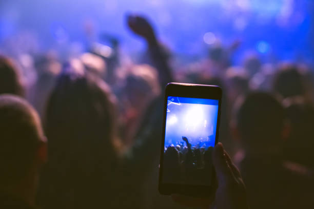 The audience is filming on the smartphone. Concert in the nightclub.