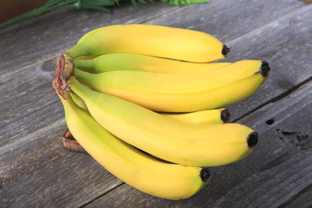 istock Ripe bananas on wooden table 897048252
