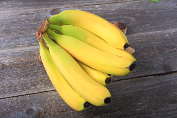 istock Ripe bananas on wooden table 897048348