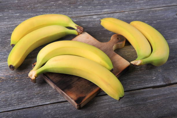 istock Ripe bananas on wooden table 897048460
