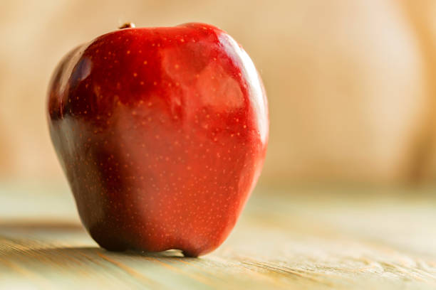 istock Red juice ripe apple on wooden background 897048464