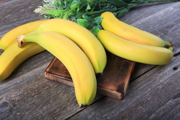 istock Ripe bananas on wooden table 897048544