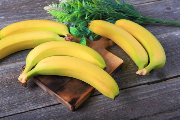 istock Ripe bananas on wooden table 897048546