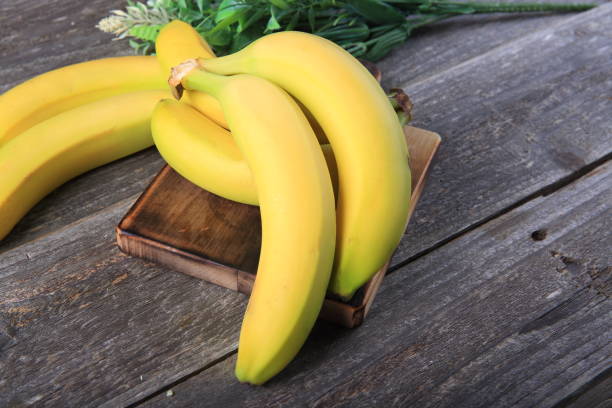 istock Ripe bananas on wooden table 897048552