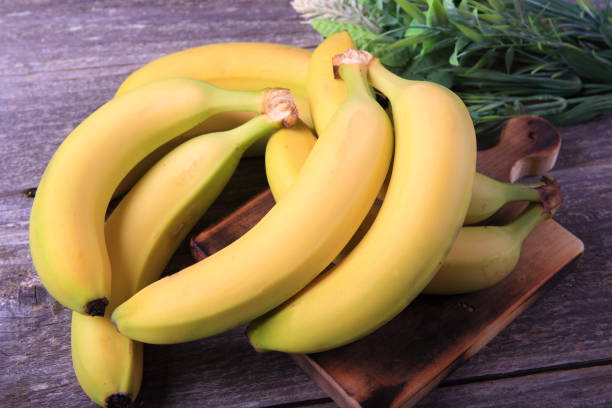 나무 테이블에 익은 바나나 - banana bunch yellow healthy lifestyle 뉴스 사진 이미지