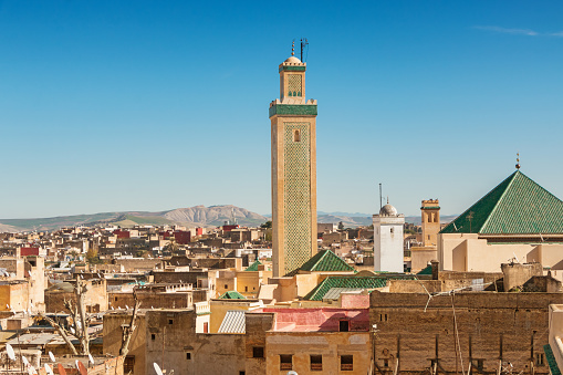 Cityscape stock photograph of old town Fez with the landmark Kairaouine Mosque Minaret in Morocco on a sunny day.