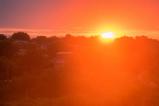 Skyline and sun setting or rising on orange background of rural sunset