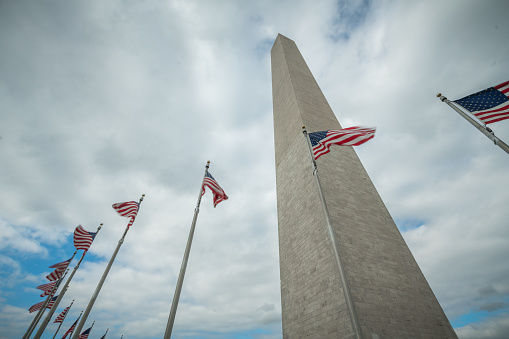 Washington Monument with clouds and American Flags in Washington DC - Zoom In