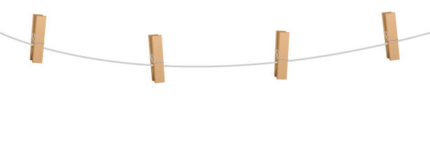 istock Clothes pins on a clothes line rope  - four wooden pegs holding nothing. 897077312