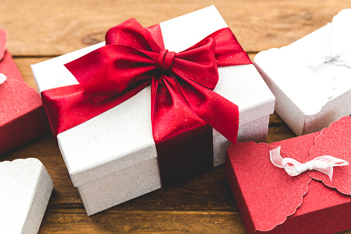 Wrapped present box with red bow on wooden board. holidays concept. Birthday, Valentines day, Christmas, New Year.