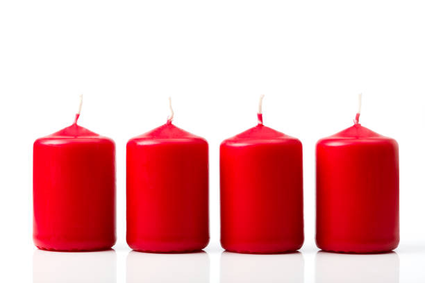 traditional advent candles with numbers and gifts on red background, selective focus