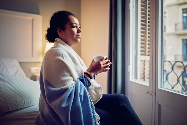 istock Nostalgic woman is looking through the window and drinking tea in the morning 897102216