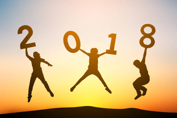 istock Silhouette Children Holding Numbers While Jumping Against Sky During Sunset 897111560