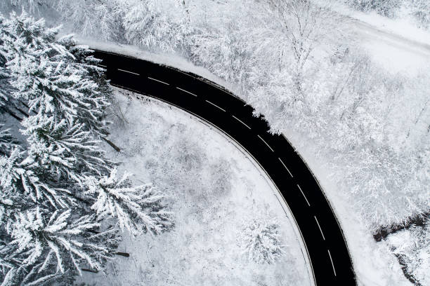 istock Road through wintery forest - aerial view 897125840