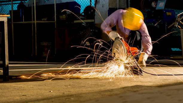 istock worker uses grinding cut metal, focus on flash light line of sharp spark,in low light 897149198
