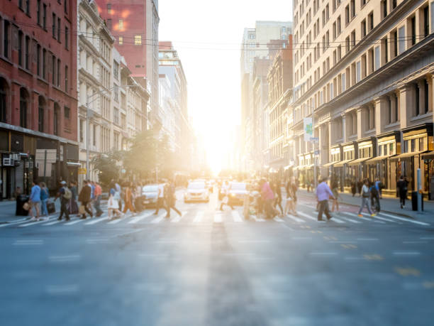 folla di persone che attraversano la strada a new york city - dusk people manhattan new york city foto e immagini stock