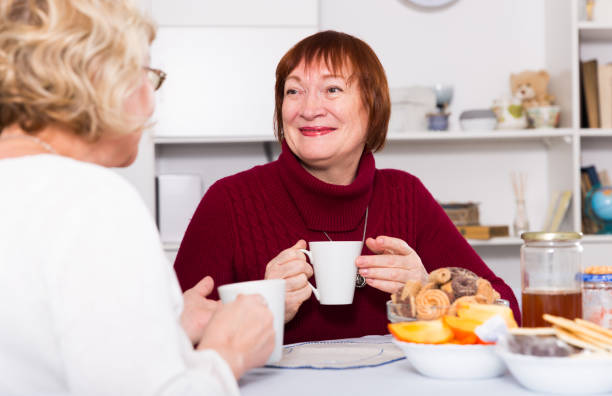 istock females talking at home with cup of tea 897173582