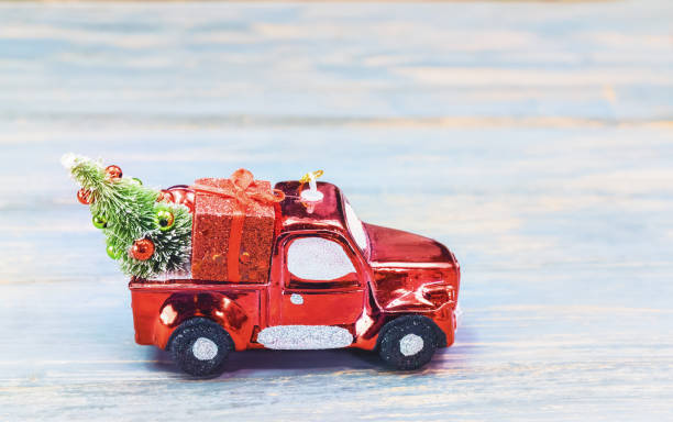 istock Miniature red car carrying fir tree on Christmas background 897191656