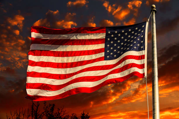 American flag in front of bright sky with white clouds