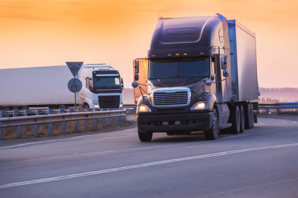 istock trucks goes on highway on sunset 897218378