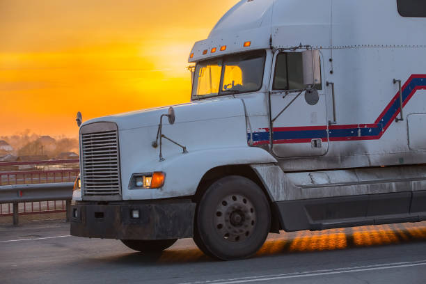 istock truck goes on highway on sunset 897221312