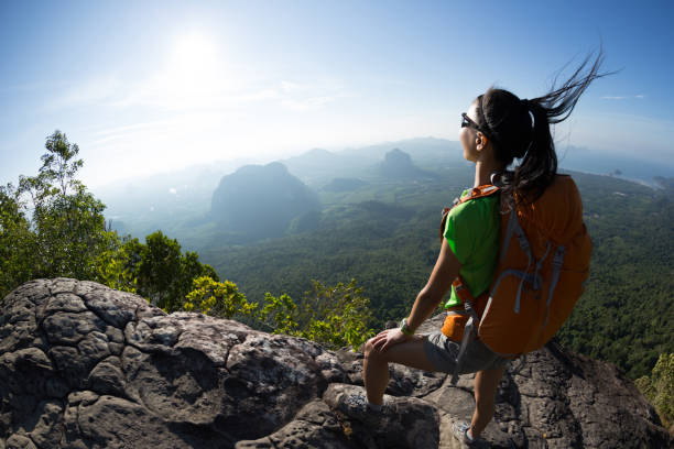 istock Young woman with backpacker enjoy the view on mountain top cliff edge 897226720
