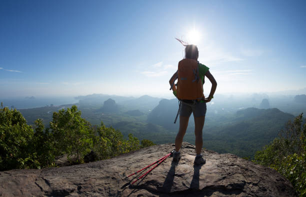 istock Young woman with backpacker enjoy the view on mountain top cliff edge 897226980