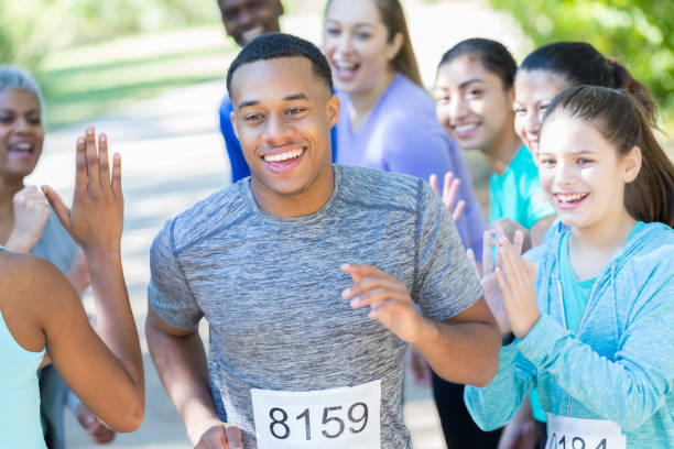 istock Young man is cheered on as he finishes race 897241140