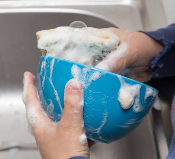 istock boy washing dishes in the kitchen 897252804