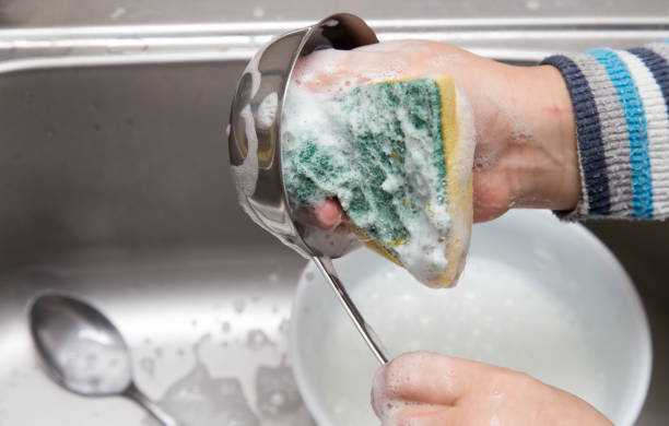 istock boy washing dishes in the kitchen 897253212