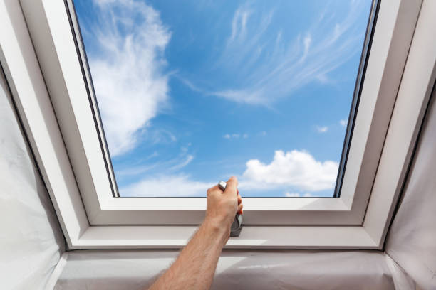 istock Man open new skylight (mansard window) in an attic room against blue sky 897277204