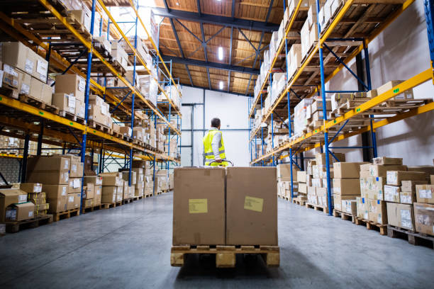 istock Male warehouse worker pulling a pallet truck. 897280154