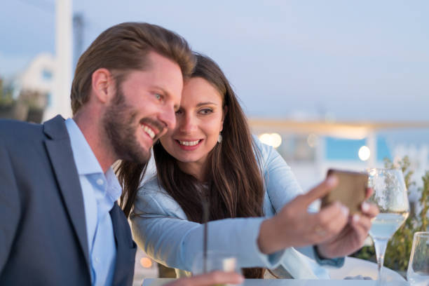 istock Discovering Greece - smiling couple dinner santorini selfie 897280446