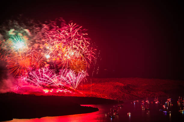 fireworks on the nea kameni volcano in santorini greece representing the volcanic eruption with burss of light excursion boats and cruise ships watching the pyrotechnic celebration