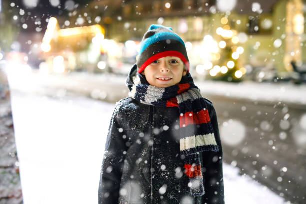 istock Happy kid boy having fun with snow in winter 897295632